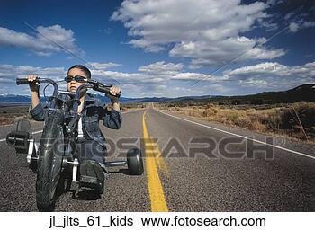 Stock Photo - portrait of a 
young boy riding 
a toy motorcycle 
on a highway. 
fotosearch - search 
stock photos, 
pictures, images, 
and photo clipart