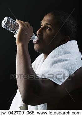 Stock Photo - teenage boy standing 
with a towel around 
his neck drinking 
water from. fotosearch 
- search stock 
photos, pictures, 
images, and photo 
clipart