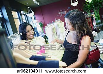 Stock Photography - two young women 
looking at clothes 
in a clothing 
store. fotosearch 
- search stock 
photos, pictures, 
images, and photo 
clipart