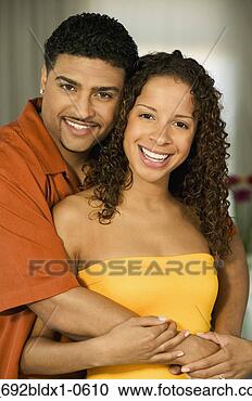 Stock Photography - young couple holding 
each other smiling 
looking at camera. 
fotosearch - search 
stock photos, 
pictures, images, 
and photo clipart