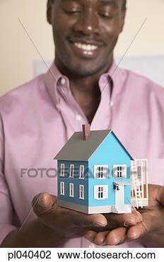 Stock Photo - young man holding 
a model of a house. 
fotosearch - search 
stock photos, 
pictures, images, 
and photo clipart
