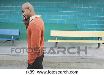 Stock Photograph - young man walking 
talking on a mobile 
phone. fotosearch 
- search stock 
photos, pictures, 
images, and photo 
clipart