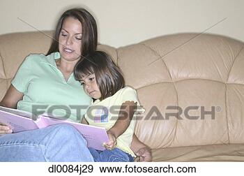 Stock Photograph - young woman sitting 
with a young girl 
on a couch reading 
a book. fotosearch 
- search stock 
photos, pictures, 
wall murals, images, 
and photo clipart