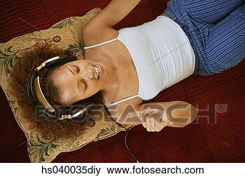 Stock Photo - high angle view 
of a young woman 
lying on the floor 
snapping fingers. 
fotosearch - search 
stock photos, 
pictures, images, 
and photo clipart