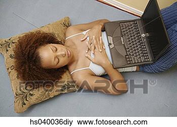 Stock Photo - high angle view 
of a young woman 
lying down with 
a laptop. fotosearch 
- search stock 
photos, pictures, 
images, and photo 
clipart