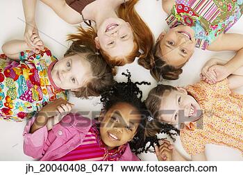 Stock Photography - high angle view 
of a group of 
young girls lying 
down together 
smiling. fotosearch 
- search stock 
photos, pictures, 
images, and photo 
clipart