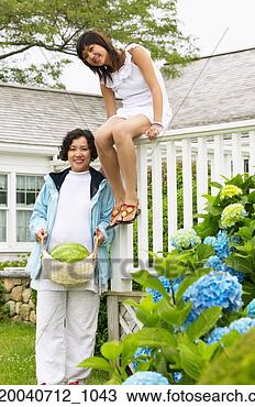 Stock Photo - portrait of a 
mid adult woman 
standing and a 
young woman sitting 
on a. fotosearch 
- search stock 
photos, pictures, 
images, and photo 
clipart