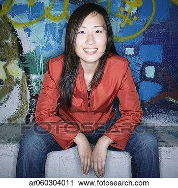 Stock Photography - portrait of a 
young woman sitting 
in front of a 
graffiti wall. 
fotosearch - search 
stock photos, 
pictures, images, 
and photo clipart
