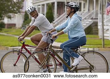 Stock Photography - side profile of 
a mid adult couple 
riding bicycles 
together. fotosearch 
- search stock 
photos, pictures, 
images, and photo 
clipart