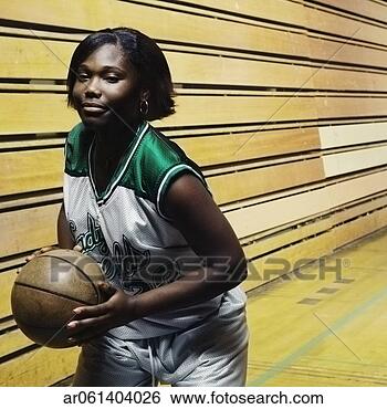 Stock Photo - teenage girl basketball 
player holding 
a basketball on 
a basketball. 
fotosearch - search 
stock photos, 
pictures, images, 
and photo clipart