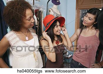 Stock Photo - three young women 
trying a hat in 
a department store. 
fotosearch - search 
stock photos, 
pictures, images, 
and photo clipart