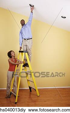 Stock Photo - young man standing 
on a ladder with 
a young woman 
standing beside 
him. fotosearch 
- search stock 
photos, pictures, 
images, and photo 
clipart