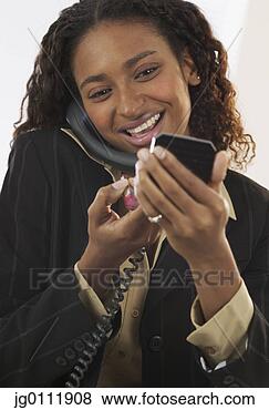Stock Photo - close-up of a 
businesswoman 
applying make 
up talking on 
a landline. fotosearch 
- search stock 
photos, pictures, 
images, and photo 
clipart