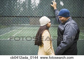 Stock Photo - side profile of 
a young couple 
standing beside 
a chain-link fence. 
fotosearch - search 
stock photos, 
pictures, images, 
and photo clipart