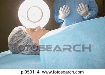 Stock Photo - close-up of a 
female patient 
lying on a bed 
in an operating 
theatre. fotosearch 
- search stock 
photos, pictures, 
images, and photo 
clipart
