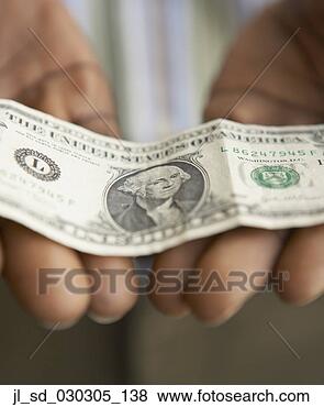 Stock Photo - close-up of a 
mid adult man 
holding an american 
dollar bill. fotosearch 
- search stock 
photos, pictures, 
images, and photo 
clipart