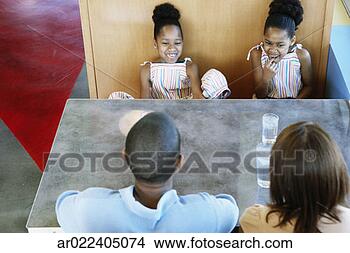 Stock Photo - high angle view 
of a family sitting 
in a restaurant. 
fotosearch - search 
stock photos, 
pictures, images, 
and photo clipart