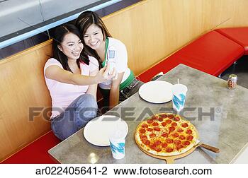 Stock Photo - high angle view 
of two young women 
taking a photograph 
of themselves. 
fotosearch - search 
stock photos, 
pictures, images, 
and photo clipart