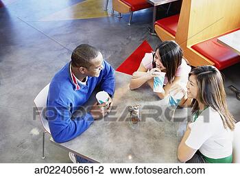 Stock Photo - high angle view 
of two young women 
and a young man 
sitting in a. 
fotosearch - search 
stock photos, 
pictures, images, 
and photo clipart
