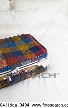 Stock Photo - high angle view 
of a suitcase 
on a bed. fotosearch 
- search stock 
photos, pictures, 
images, and photo 
clipart