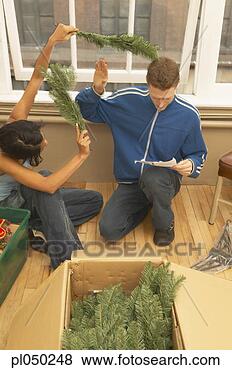 Stock Photo - high angle view 
of a young couple 
in front of christmas 
tree. fotosearch 
- search stock 
photos, pictures, 
images, and photo 
clipart