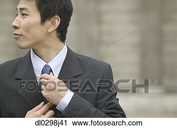 Stock Photography - mid adult businessman 
tying his tie. 
fotosearch - search 
stock photos, 
pictures, images, 
and photo clipart