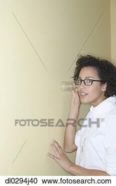 Stock Photography - mid adult woman 
listening through 
a wall with a 
glass. fotosearch 
- search stock 
photos, pictures, 
images, and photo 
clipart