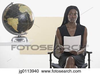 Stock Photography - mid adult woman 
sitting on a chair 
holding a document 
near a globe. 
fotosearch - search 
stock photos, 
pictures, images, 
and photo clipart