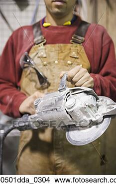 Stock Photo - mid section view 
of a male construction 
worker holding 
an electric saw. 
fotosearch - search 
stock photos, 
pictures, images, 
and photo clipart