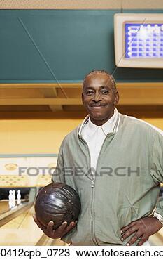 Stock Photo - portrait of a 
mature man holding 
a bowling ball 
in a bowling alley. 
fotosearch - search 
stock photos, 
pictures, images, 
and photo clipart