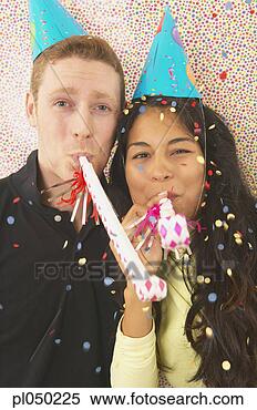 Stock Image - portrait of a 
young couple blowing 
party horn blowers 
at a birthday. 
fotosearch - search 
stock photos, 
pictures, images, 
and photo clipart
