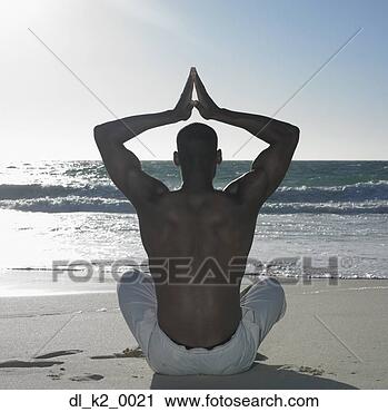 Stock Photography - rear view of a 
young adult man 
performing yoga 
on the beach. 
fotosearch - search 
stock photos, 
pictures, images, 
and photo clipart
