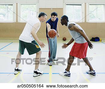 Stock Photo - two young men 
and a mid adult 
man playing basketball 
in the. fotosearch 
- search stock 
photos, pictures, 
images, and photo 
clipart