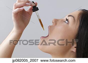 Picture - young woman taking 
a dropper of liquid 
medicine. fotosearch 
- search stock 
photos, pictures, 
images, and photo 
clipart