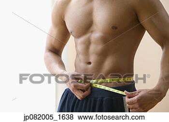 Stock Photo - mid section of 
man measuring 
his waist with 
measuring tape. 
fotosearch - search 
stock photos, 
pictures, images, 
and photo clipart