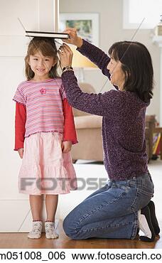 Stock Photo - mother measuring 
daughter's height. 
fotosearch - search 
stock photos, 
pictures, images, 
and photo clipart