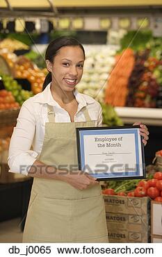 Stock Image - portrait of grocery 
employee holding 
employee of the 
month plaque. 
fotosearch - search 
stock photos, 
pictures, images, 
and photo clipart