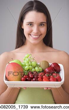 Stock Photograph - portrait of teenage 
girl holding plate 
of fresh fruit. 
fotosearch - search 
stock photos, 
pictures, images, 
and photo clipart