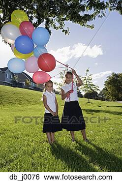 Stock Photo - portrait of two 
girls holding 
balloons in backyard. 
fotosearch - search 
stock photos, 
pictures, images, 
and photo clipart