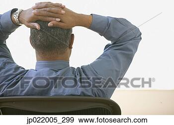Stock Photograph - rear view of african 
american man sitting 
in chair with 
arms raised. fotosearch 
- search stock 
photos, pictures, 
images, and photo 
clipart