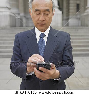 Stock Photography - senior asian businessman 
using electronic 
organizer. fotosearch 
- search stock 
photos, pictures, 
images, and photo 
clipart