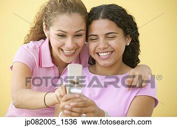 Stock Photo - two teenage girls 
text messaging 
on cell phone. 
fotosearch - search 
stock photos, 
pictures, images, 
and photo clipart