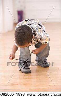 Stock Photo - young boy bent 
over tying shoe. 
fotosearch - search 
stock photos, 
pictures, images, 
and photo clipart