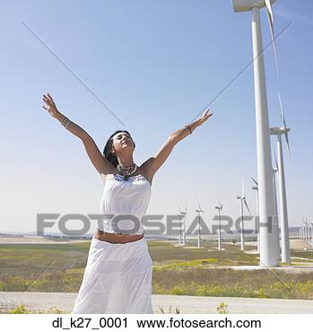 Stock Photography - young woman with 
outstretched arms 
by wind turbines. 
fotosearch - search 
stock photos, 
pictures, images, 
and photo clipart