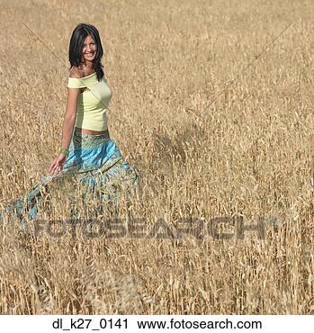 Stock Photography - young woman strolling 
in field. fotosearch 
- search stock 
photos, pictures, 
images, and photo 
clipart