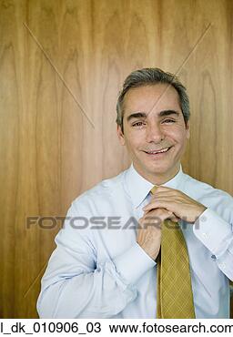 Stock Photo - businessman tying 
his tie. fotosearch 
- search stock 
photos, pictures, 
images, and photo 
clipart