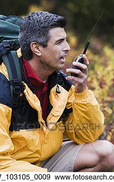 Stock Photograph - man talking into 
a walkie-talkie 
outdoors. fotosearch 
- search stock 
photos, pictures, 
images, and photo 
clipart