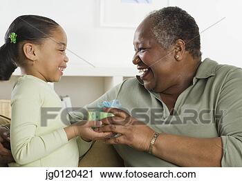 Stock Photography - senior woman giving 
her granddaughter 
a gift. fotosearch 
- search stock 
photos, pictures, 
images, and photo 
clipart