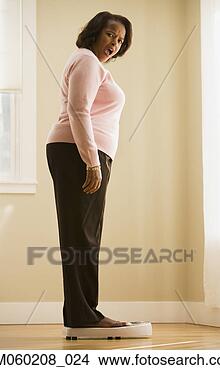 Stock Photo - woman weighing 
herself. fotosearch 
- search stock 
photos, pictures, 
images, and photo 
clipart