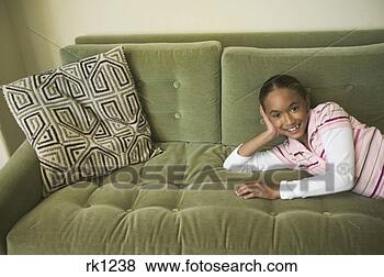 Stock Photo - young girl relaxing 
on a couch. fotosearch 
- search stock 
photos, pictures, 
images, and photo 
clipart